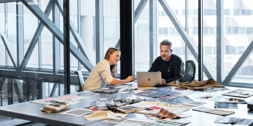 Two individuals engaged in a laptop task within an office, highlighting the concept of staff augmentation.