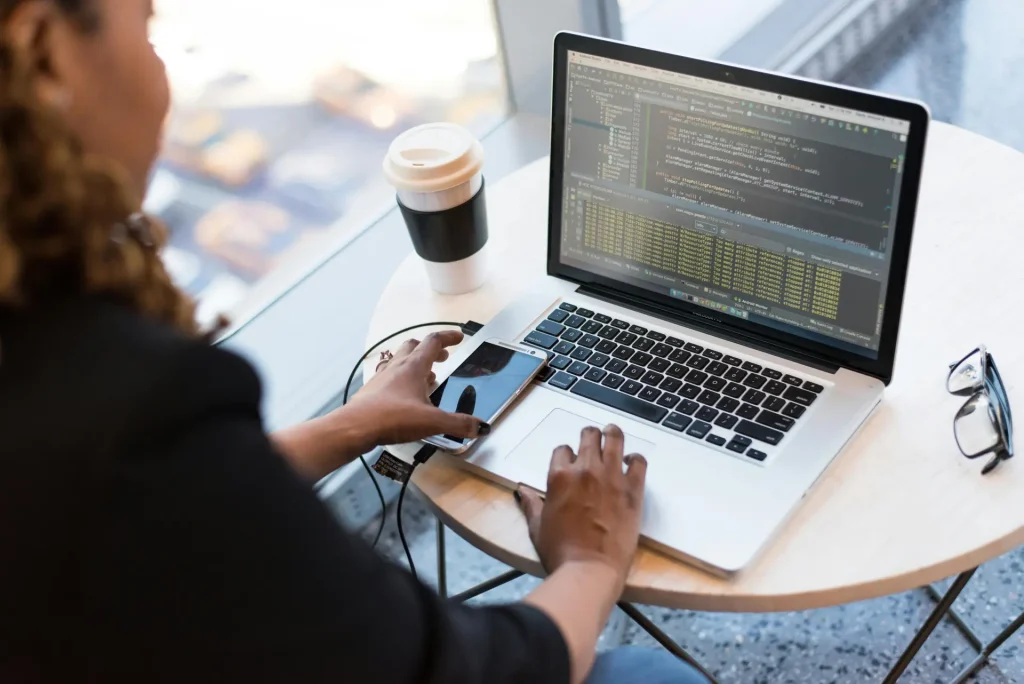 A Java Web developer typing on her laptop keyboard to code.