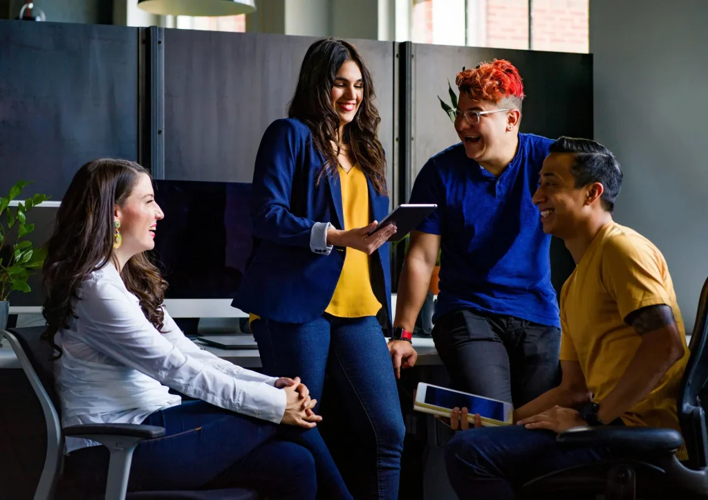 A diverse group of individuals sitting around a table, engaged in a meeting or discussion.